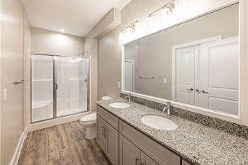 A bathroom with a sink, mirror, and shower at Foxwood Apartments, North Carolina